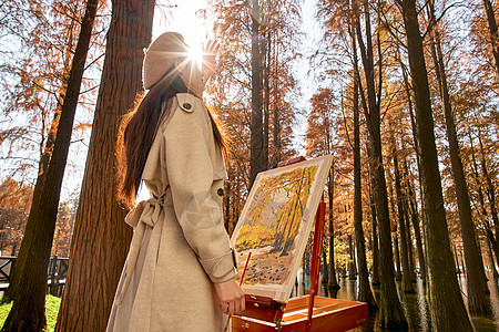阳光下的树林逆光下的秋冬美女户外画画背景