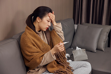 冬日女性感冒发烧使用体温计背景图片