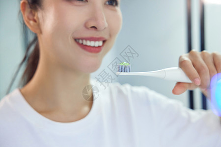 居家女性使用电动牙刷特写图片