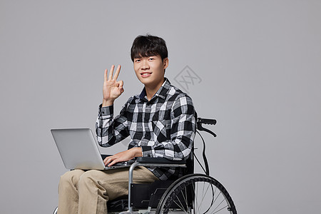 坐轮椅的男性使用电脑比ok手势图片
