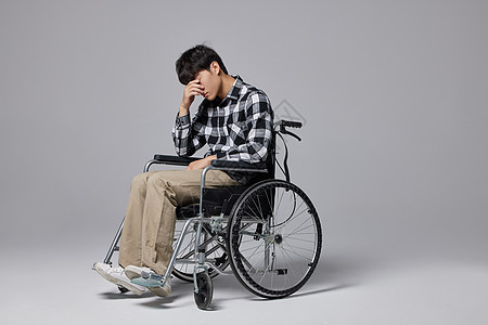 沮丧的青年男性坐轮椅图片