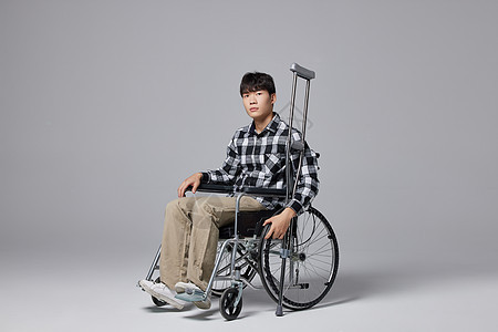 青年男性腿部受伤坐轮椅形象图片