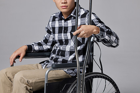 青年男性腿部受伤坐轮椅特写图片