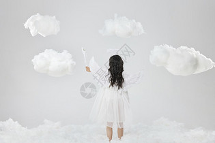 可爱天使小女孩伸手摸云朵背影图片