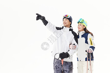 年轻情侣一起滑雪手指前方图片