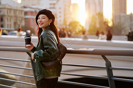 街拍夕阳下散步的街边时尚美女背景