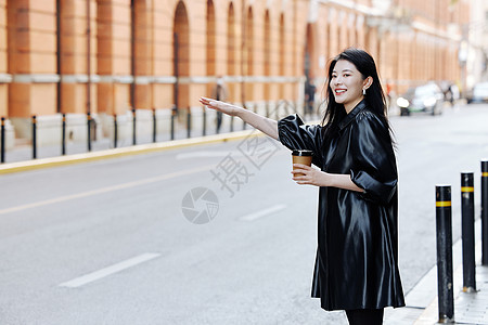 时尚美女手拿咖啡的青年女性招手拦车背景