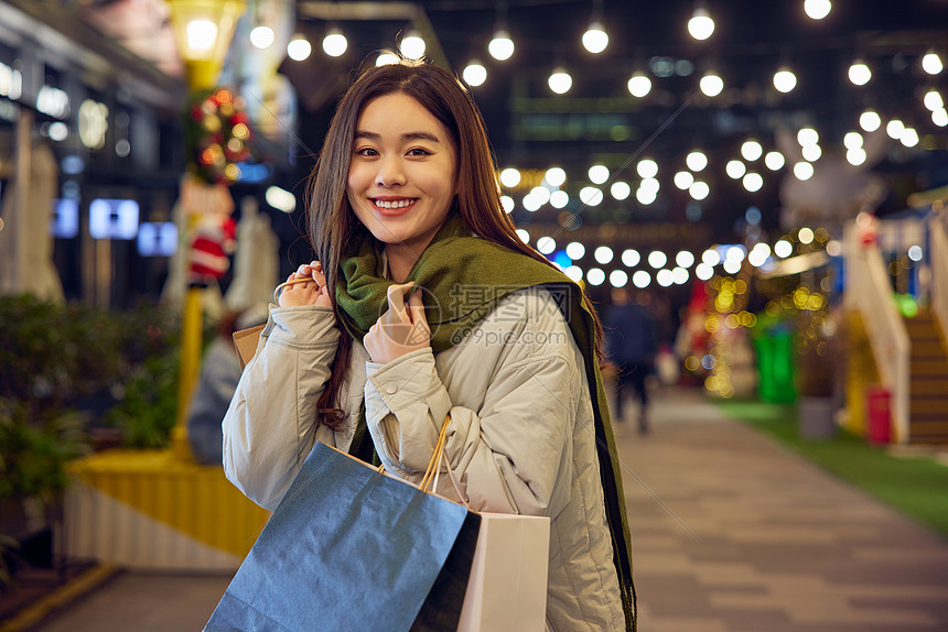 手提购物袋的年轻女性图片