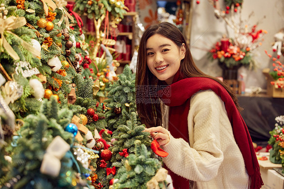 年轻美女挑选圣诞装饰图片