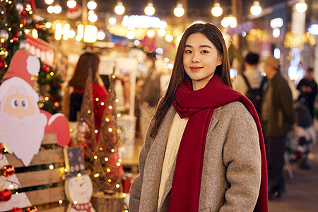 冬日女性夜晚逛圣诞市集图片