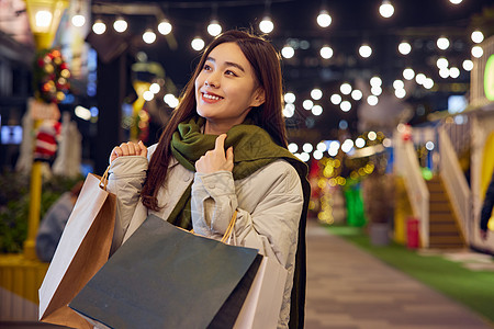 冬日女性夜晚逛街购物图片