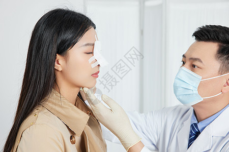 医生为鼻子整容的女性患者做复查图片