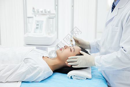 医生给美女顾客做面部医美护理高清图片