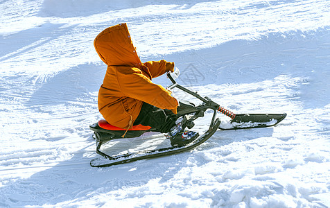 雪地里玩雪橇的小男孩高清图片