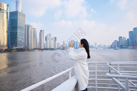 浦江游轮船上拍照打卡的旅游女生高清图片