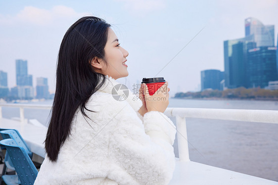 白天在游轮船手捧咖啡杯的旅游女生图片