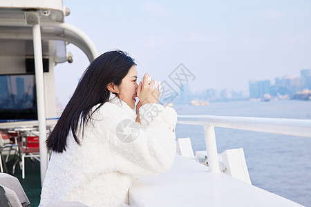 白天在浦江游轮船上拍照打卡的旅游女生高清图片