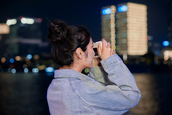 夜晚正在使用相机拍照的女生图片