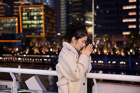 都市时尚夜晚在游轮船上搓手取暖的旅游女生背景