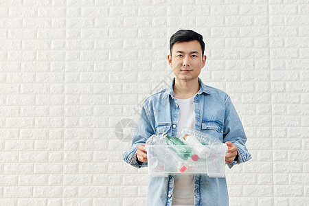 男性拿着塑料瓶回收再利用图片