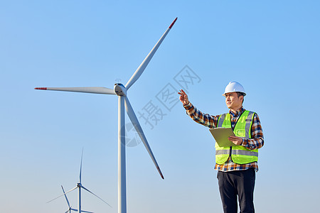 绿色节能男性工程师勘察风力发电大风车背景