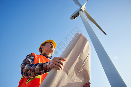 绿色节能仰拍男性工程师在大风车下看图纸背景