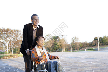 爷爷推轮椅上的奶奶到花园里散步图片