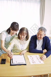 女性护工陪伴居家老人练习书法图片