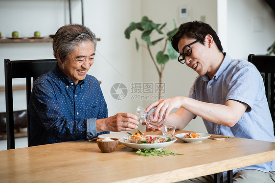 年轻男士给长辈斟酒图片