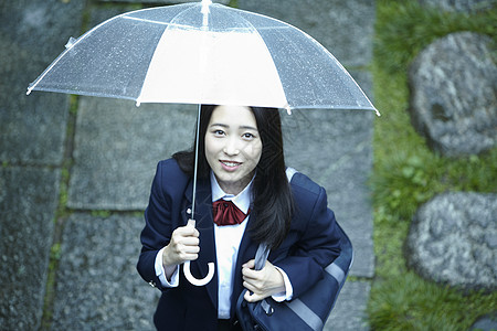 雨天撑伞上学的女高中生背景图片