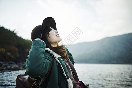 头戴帽子快乐的女人在湖边图片