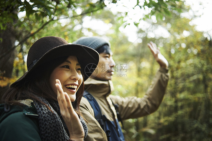 露营夫妇漫步在森林里挥手图片