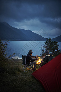 湖边露营点燃篝火的夫妇图片