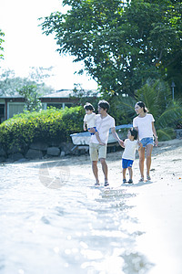父母和孩子沿着海滩散步图片