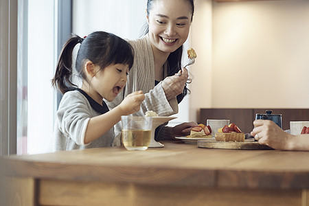 陪孩子吃甜品的母亲高清图片