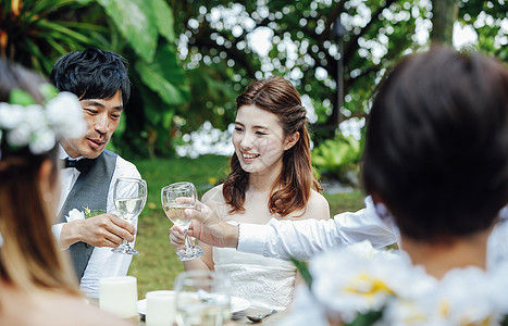 做庭院婚礼的新婚夫妇与朋友举杯高清图片