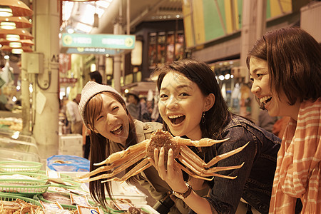 妇女在生猛海鲜观光市场挑选螃蟹背景