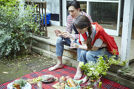 在户外野餐享受美食的年轻夫妻图片