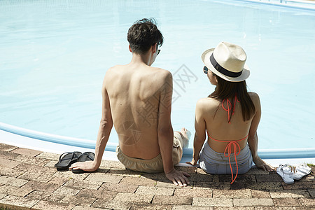 在酒店游泳池旁的年轻情侣夫妇高清图片素材