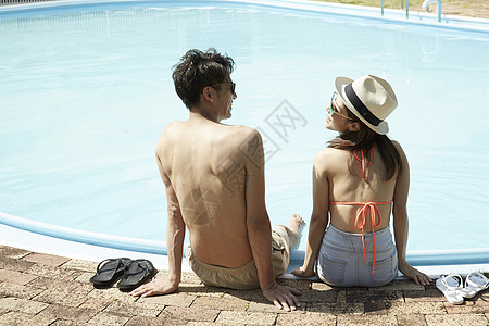年轻情侣在游泳池边玩耍假日高清图片素材