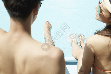 年轻情侣休闲度假在酒店泳池边玩耍洋装高清图片素材