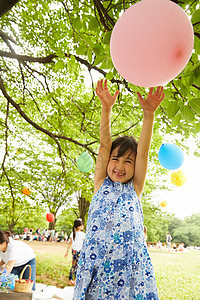 在公园里微笑玩气球的女孩图片