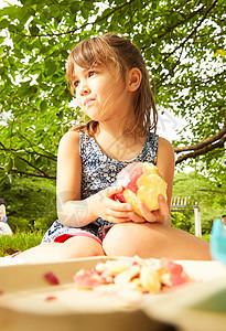 在公园野餐的小姑娘吃苹果图片