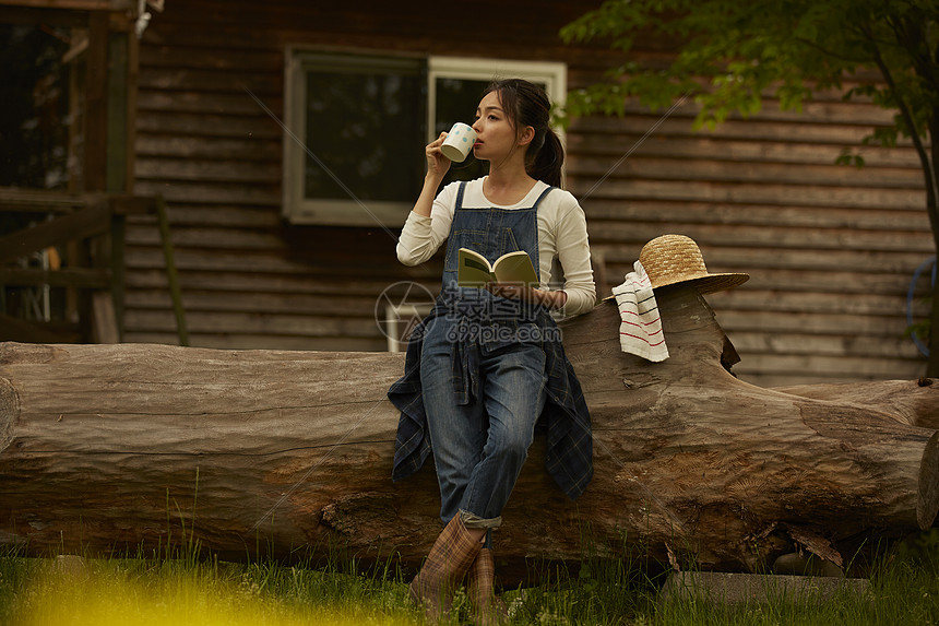 休息喝咖啡看书的农民女青年图片
