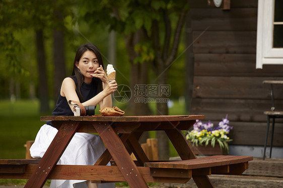 女孩一个人在外面吃奶油冰激凌图片