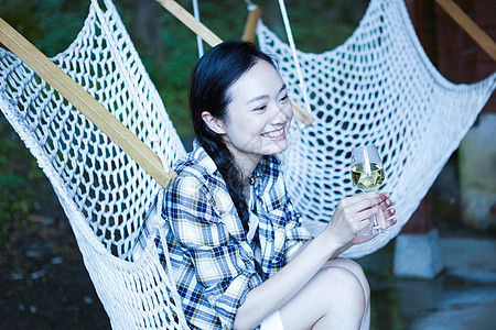 坐在吊椅上手持香槟的女孩图片