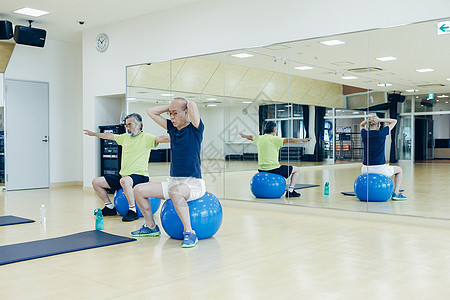 健身房瑜伽球运动的中老年人图片