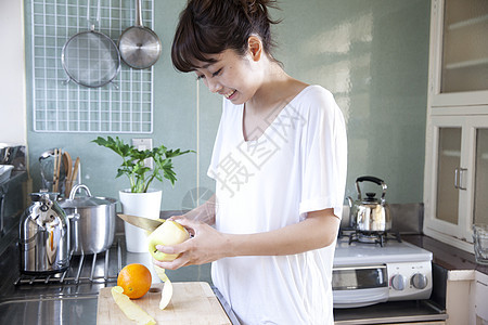 厨房水果削皮的居家女性图片