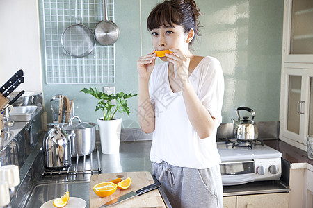 厨房吃橙子的居家女性图片