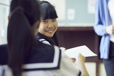 教室里转头看最好朋友的初中女学生形象图片